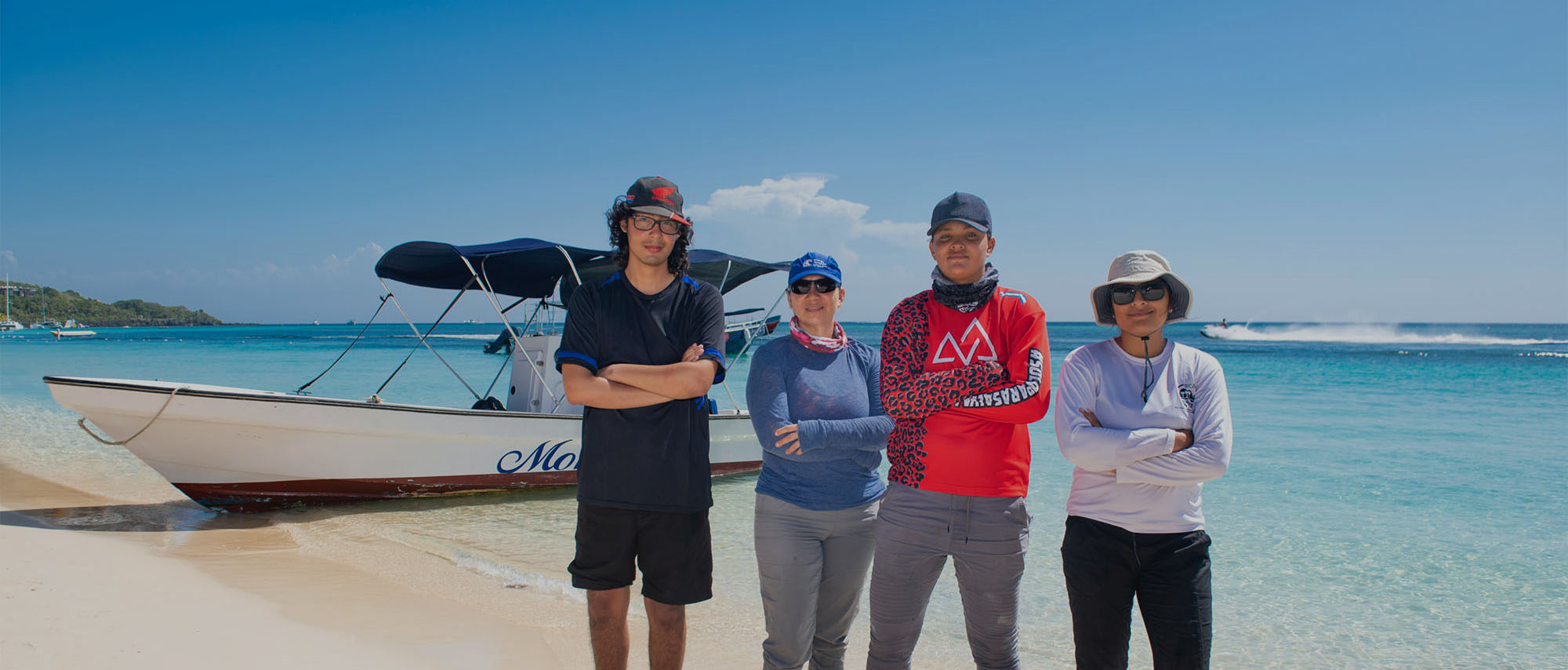 Bay Island Conservation Association staff pose by a boat in Roatan, Honduras