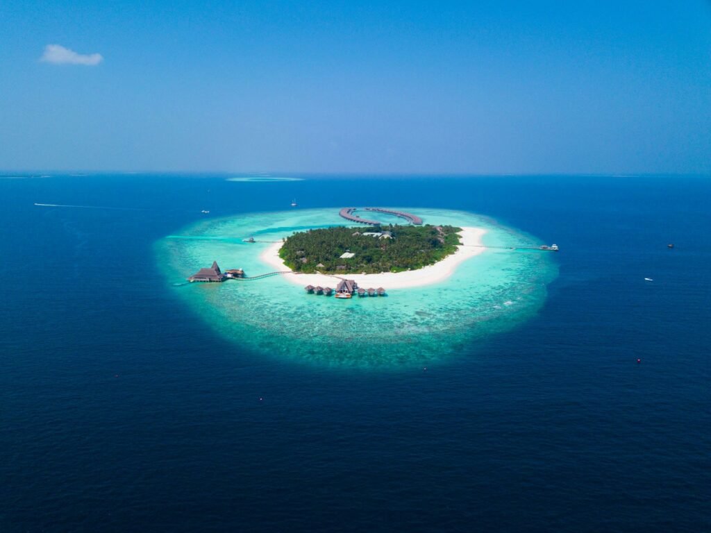 A turquoise ring of the Maldives with a green lush center and deep blue surrounding ocean